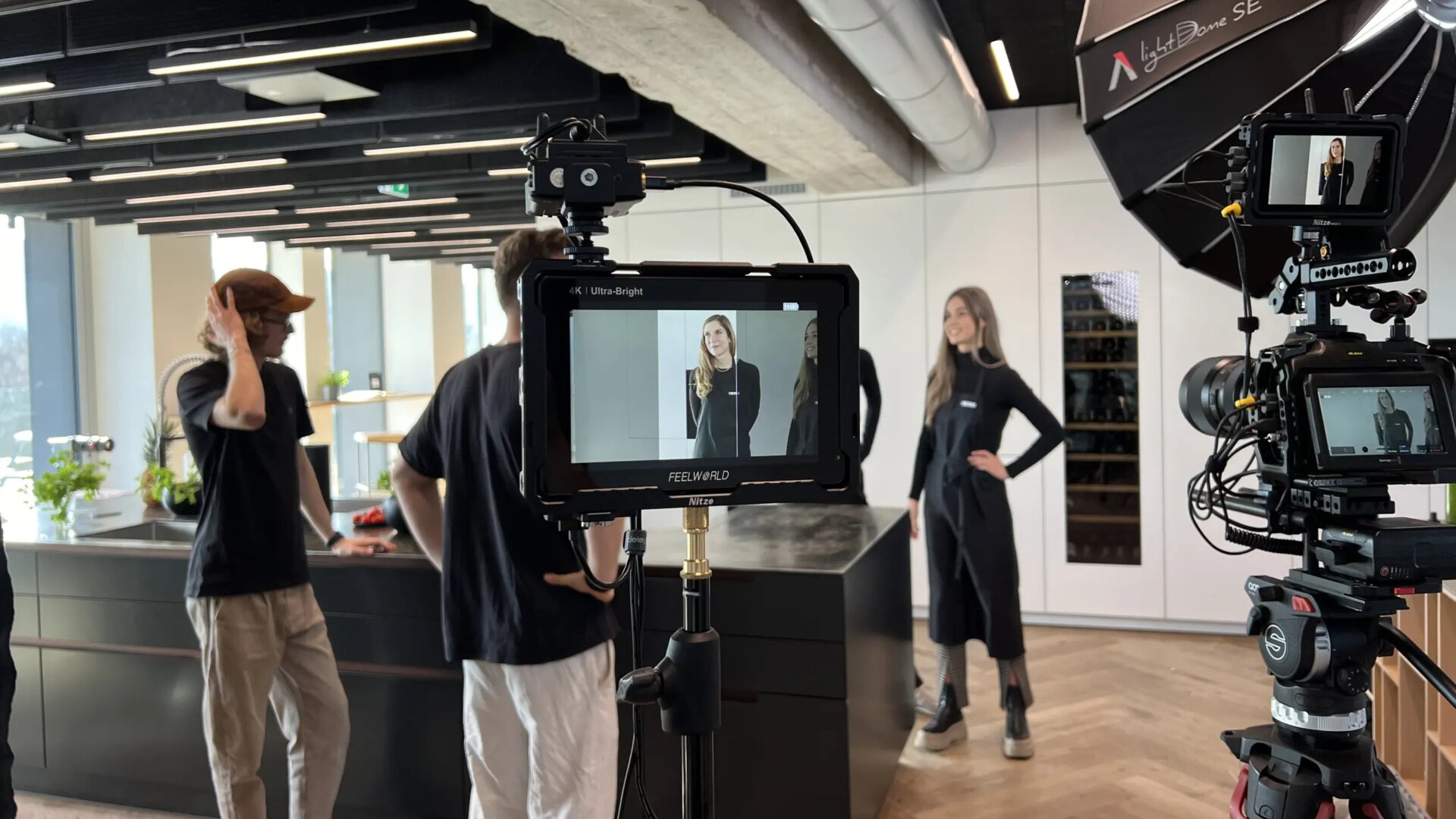 BORA Küchengeräte im Hintergrund, Team bei Fotoshooting und Videoaufnahme in moderner Küche mit BORA Kochfeldabzug.