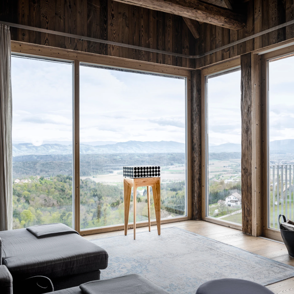 Modernes Wohnzimmer mit großem Panoramafenster und Holzelementen, markant für BORA Designästhetik.