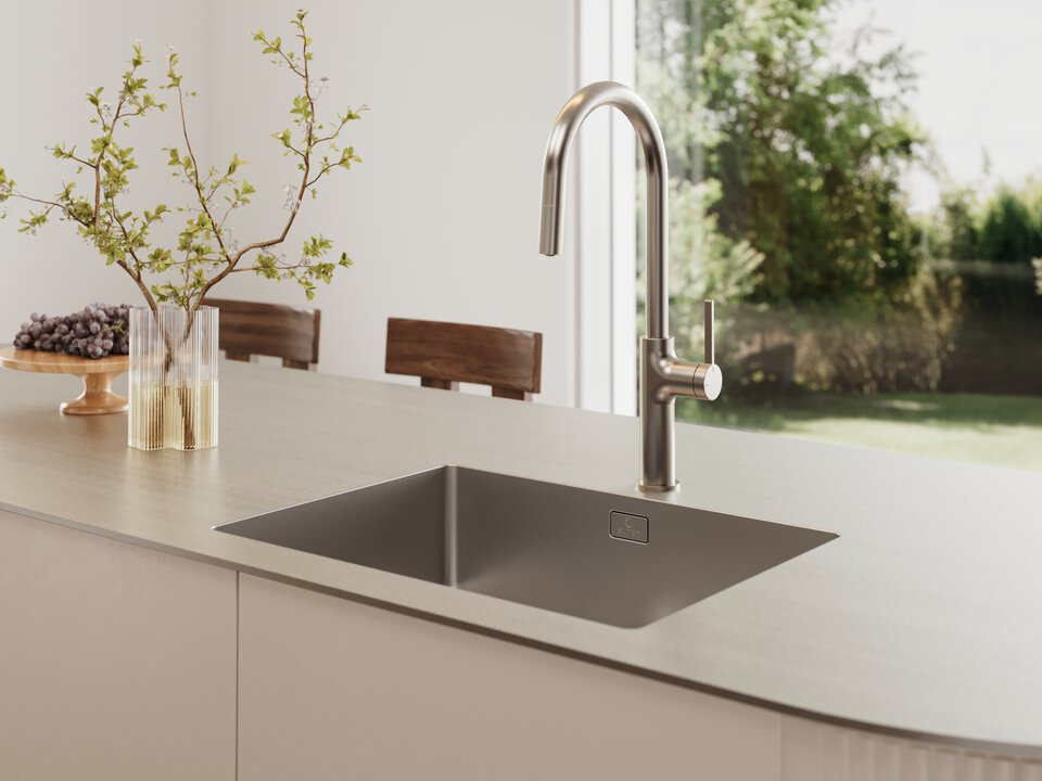 BORA Edelstahl-Einbauspüle mit modernem Armatur-Design in heller, minimalistischer Kücheninsel vor bodentiefen Fenstern.
