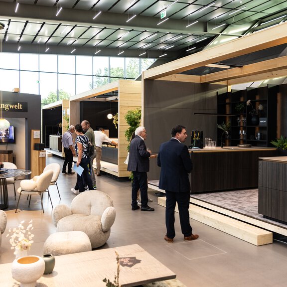 Moderne BORA Küchenwelt mit Kochfeldabzug in einer Ausstellung, Besucher erkunden innovative Küchentechnik und Designlösungen.