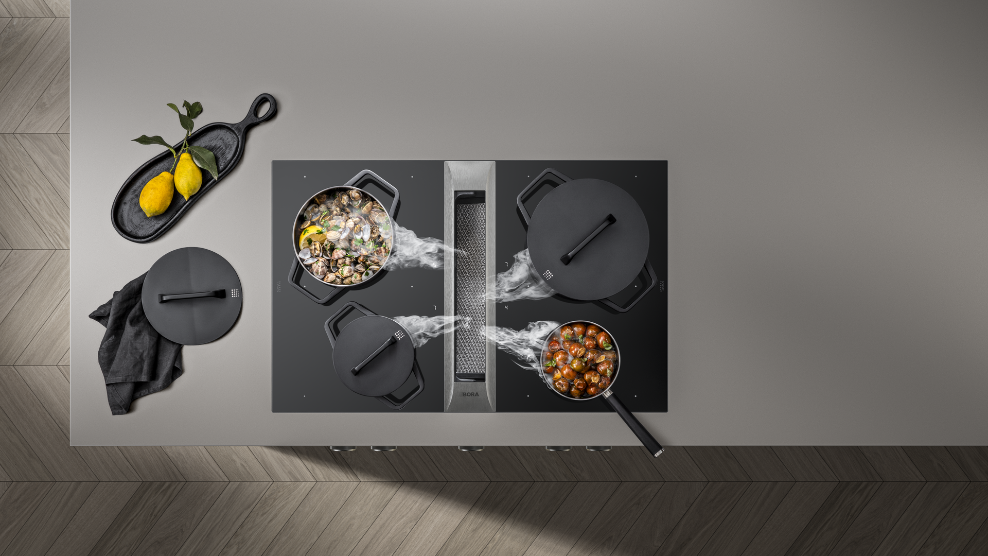 BORA Kochfeld mit integriertem Dunstabzug und dampfendem Pfannengericht.