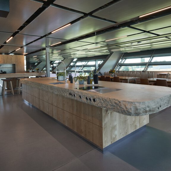 Moderne BORA Küche mit zentraler Kochinsel und integriertem BORA Kochfeldabzugssystem in großzügigem Essbereich.