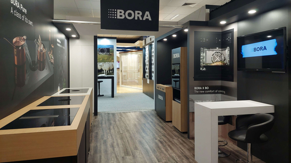 Messestand mit BORA Kochfeldabzügen und Markenbranding auf moderner Messefläche.